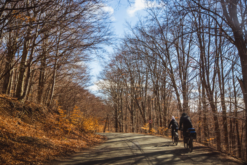 Zwei Personen auf Radtour mit Gepäck durch eine Frühlingslandschaft