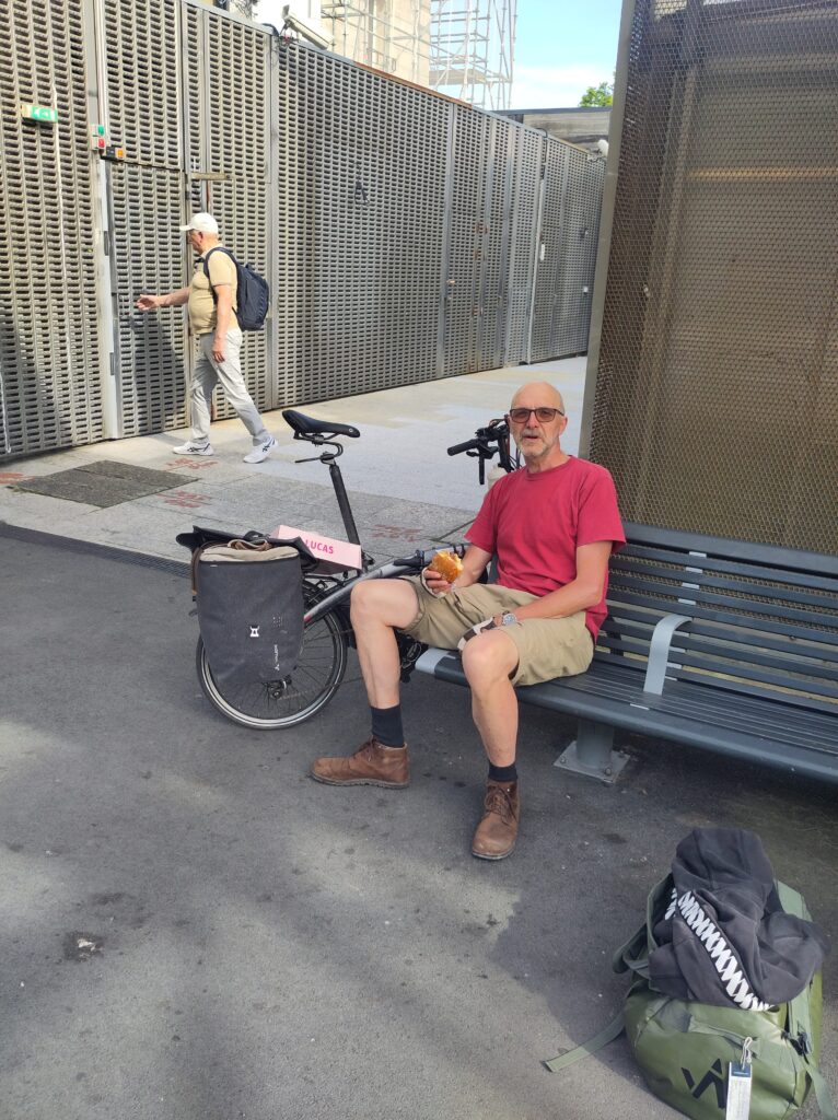 Michael auf einer Bank am Bahnhof von Bayonne. Neben ihm sein Faltrad.